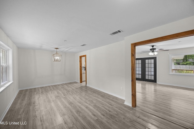 2389 Napoleon Ave, Pearl, MS 39208 - unfurnished room with ceiling fan with notable chandelier, baseboards, wood finished floors, and visible vents