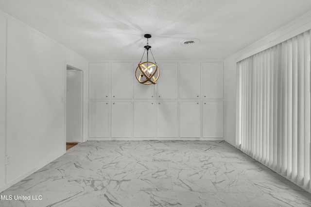 unfurnished room featuring ornamental molding and a textured ceiling