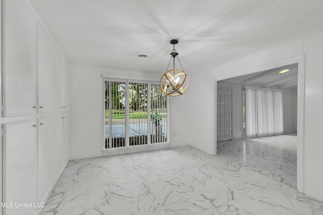 spare room featuring an inviting chandelier, a textured ceiling, and crown molding