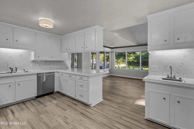 kitchen featuring kitchen peninsula, a textured ceiling, stainless steel dishwasher, and sink