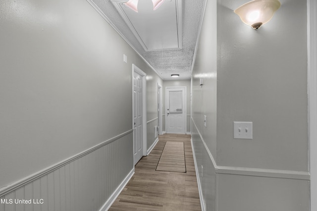 corridor featuring light hardwood / wood-style floors and a textured ceiling