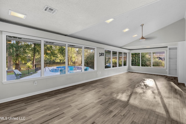 unfurnished sunroom featuring vaulted ceiling and plenty of natural light