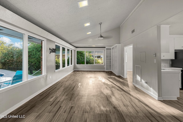 interior space with a textured ceiling, wood-type flooring, and high vaulted ceiling