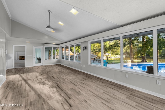 interior space featuring a textured ceiling, lofted ceiling, and hardwood / wood-style floors