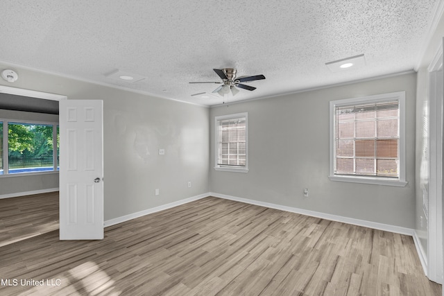 unfurnished room with ceiling fan, a textured ceiling, light wood-type flooring, and plenty of natural light