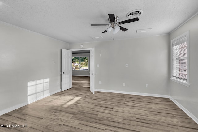 spare room with crown molding, a textured ceiling, light wood-type flooring, and ceiling fan