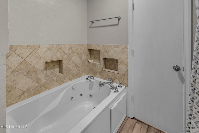 bathroom with a bath and hardwood / wood-style flooring