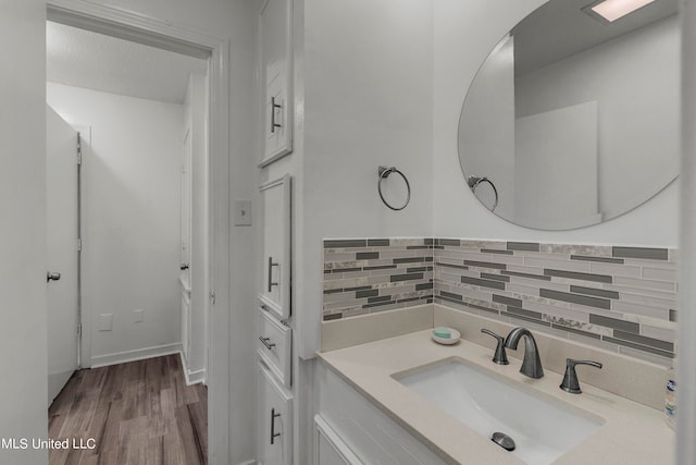 bathroom with vanity, hardwood / wood-style floors, tasteful backsplash, and a textured ceiling