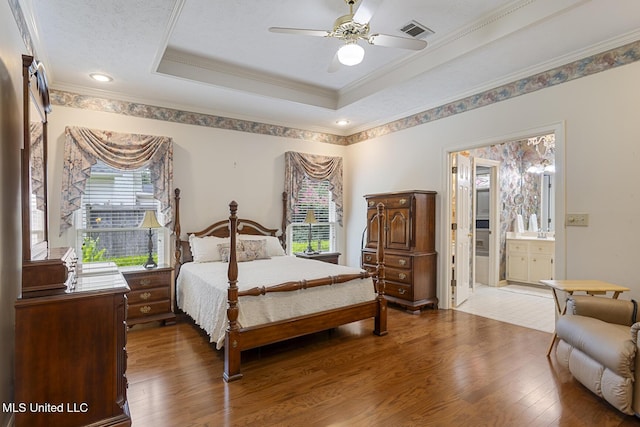 20 Peachtree Ln, Madison, MS 39110 - bedroom with wood finished floors, crown molding, ensuite bath, a tray ceiling, and a ceiling fan