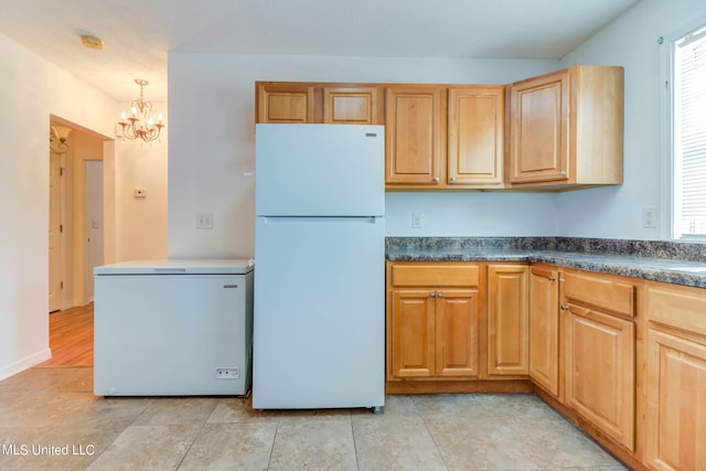 kitchen featuring refrigerator, a chandelier, pendant lighting, light hardwood / wood-style floors, and white fridge