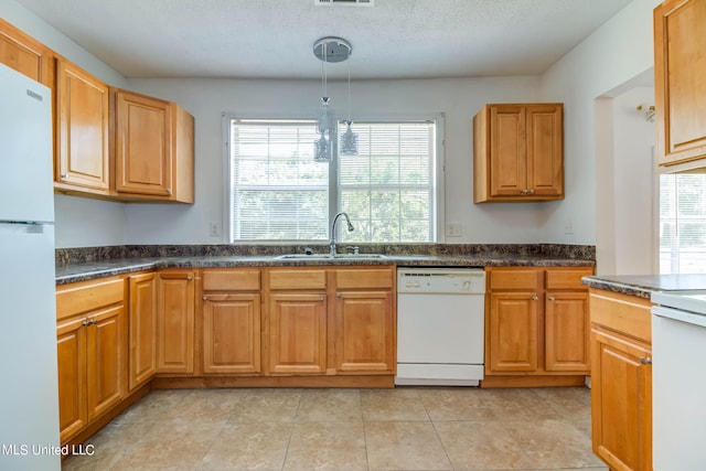 kitchen featuring a wealth of natural light, sink, pendant lighting, and white appliances