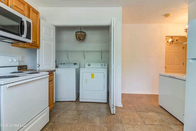 laundry room featuring washing machine and dryer and light tile patterned floors