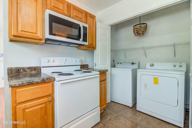 kitchen with independent washer and dryer, white electric stove, and light tile patterned floors