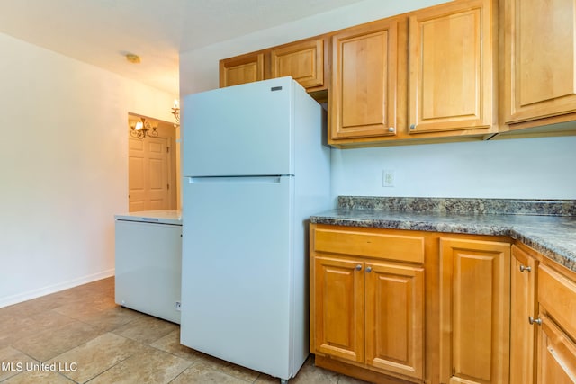 kitchen with a notable chandelier and white refrigerator