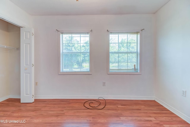 unfurnished bedroom with light hardwood / wood-style flooring and a closet