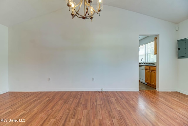 spare room with lofted ceiling, electric panel, a chandelier, light hardwood / wood-style floors, and sink