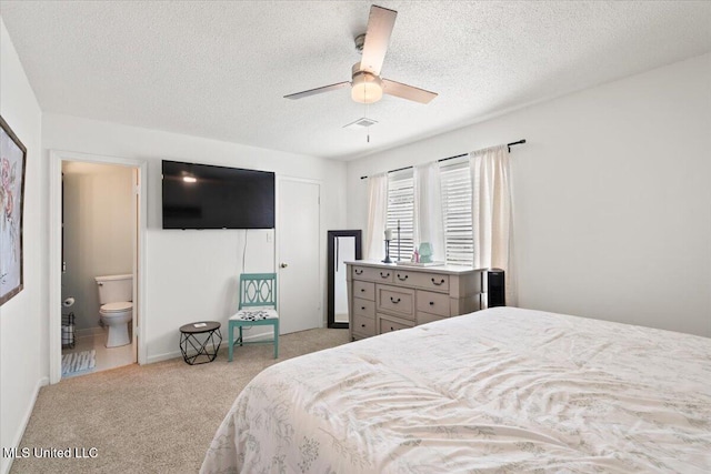 bedroom featuring visible vents, a textured ceiling, ensuite bath, carpet floors, and ceiling fan