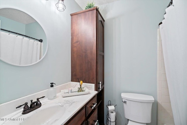 bathroom featuring a textured ceiling, toilet, and vanity