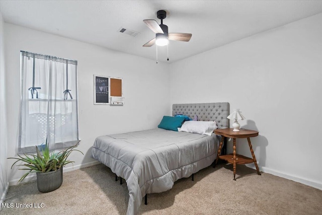 carpeted bedroom with visible vents, baseboards, and a ceiling fan