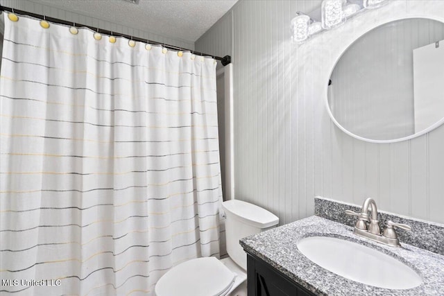 bathroom featuring a shower with shower curtain, toilet, a textured ceiling, and vanity