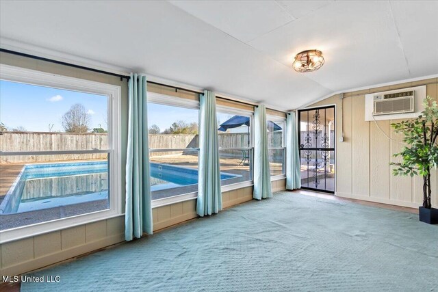 unfurnished sunroom featuring a wall mounted AC and vaulted ceiling