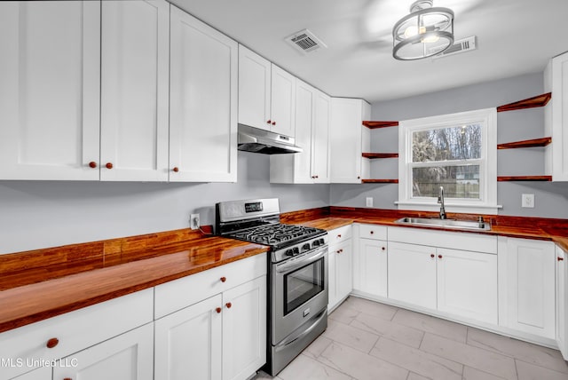 kitchen featuring open shelves, visible vents, stainless steel gas stove, a sink, and under cabinet range hood