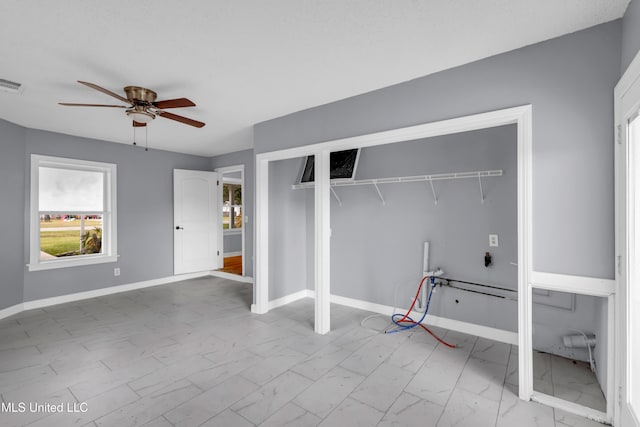 washroom featuring marble finish floor, a ceiling fan, and baseboards