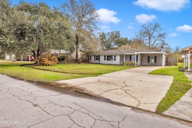 ranch-style home featuring a carport, driveway, and a front lawn