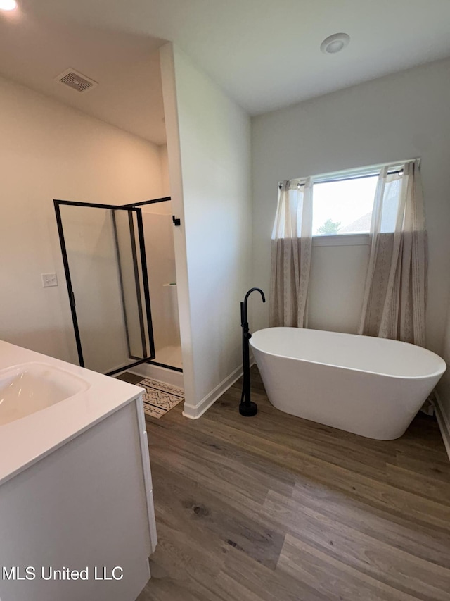 126 Deerfield Trce, Coldwater, MS 38618 - bathroom with wood finished floors, vanity, a shower stall, a freestanding tub, and baseboards