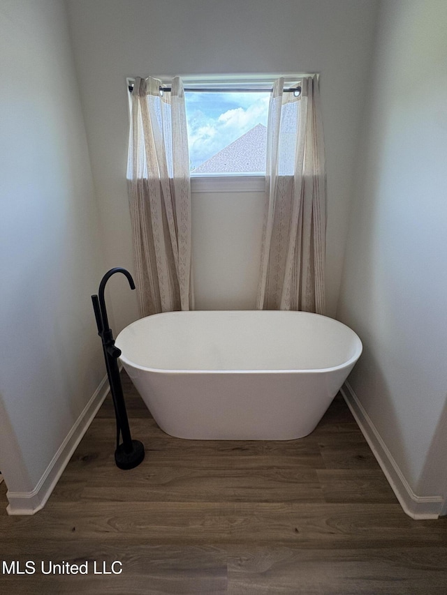 126 Deerfield Trce, Coldwater, MS 38618 - full bathroom featuring a soaking tub, wood finished floors, and baseboards