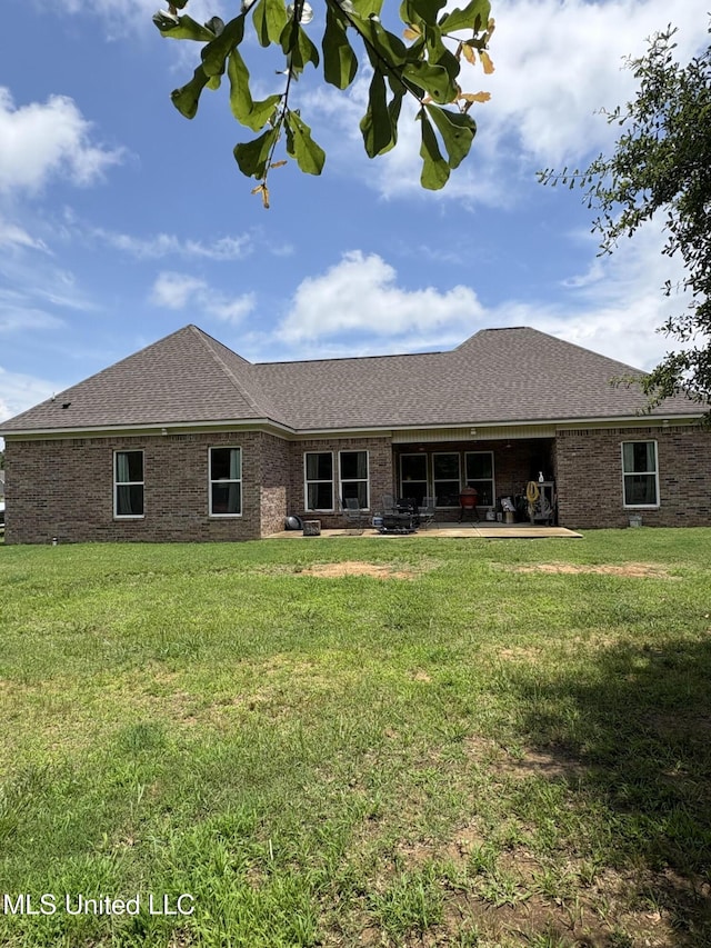 126 Deerfield Trce, Coldwater, MS 38618 - back of house featuring a yard, a shingled roof, a patio area, and brick siding