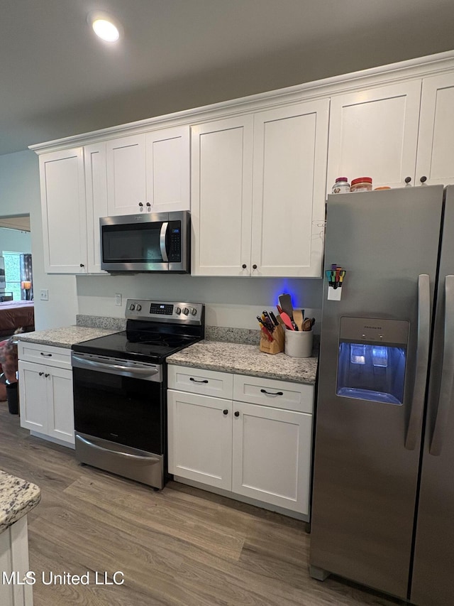 126 Deerfield Trce, Coldwater, MS 38618 - kitchen with stainless steel appliances, white cabinets, wood finished floors, and light stone countertops