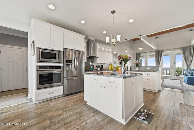 7101 Belle Fontaine Dr, Ocean Springs, MS 39564 - kitchen with appliances with stainless steel finishes, wall chimney range hood, decorative backsplash, a chandelier, and white cabinets