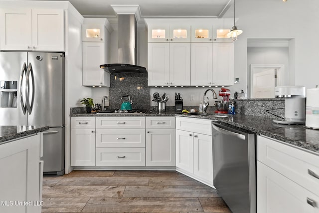 7101 Belle Fontaine Dr, Ocean Springs, MS 39564 - kitchen with appliances with stainless steel finishes, wall chimney range hood, crown molding, white cabinetry, and glass insert cabinets