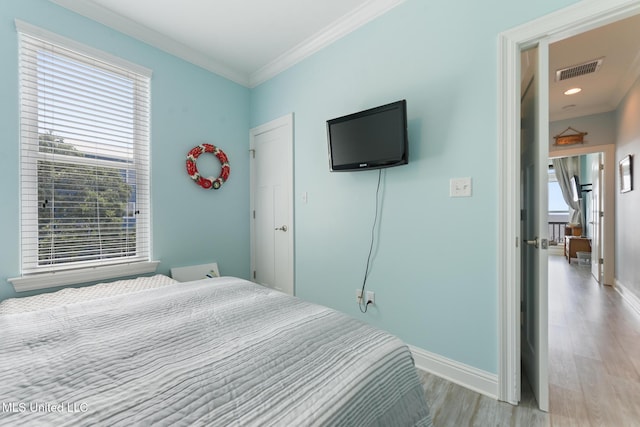 7101 Belle Fontaine Dr, Ocean Springs, MS 39564 - bedroom with light wood-type flooring and ornamental molding