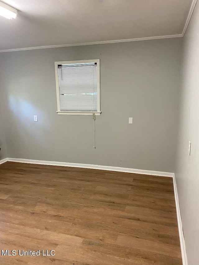 empty room featuring hardwood / wood-style floors and crown molding