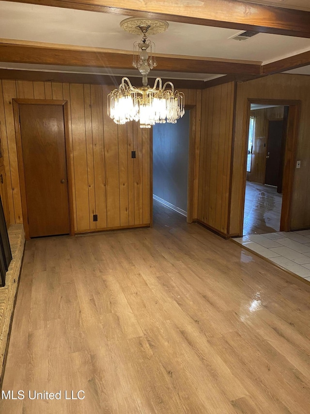 102 Brooklyn Dr, Natchez, MS 39120 - unfurnished dining area featuring light wood finished floors, beam ceiling, wood walls, and a chandelier