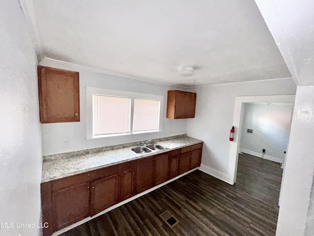 1004 Spengler St, Jackson, MS 39202 - kitchen with a sink, dark wood-style flooring, light countertops, baseboards, and brown cabinets
