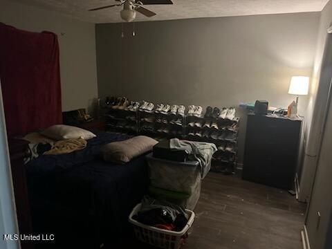 bedroom with hardwood / wood-style flooring, ceiling fan, and a textured ceiling