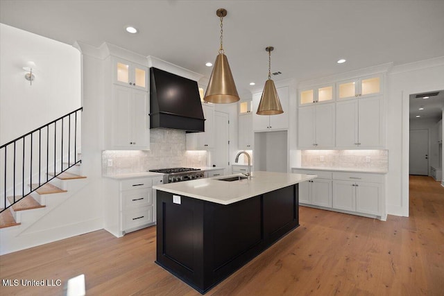 125 Water St, Madison, MS 39110 - kitchen with custom exhaust hood, backsplash, light countertops, light wood-type flooring, and recessed lighting