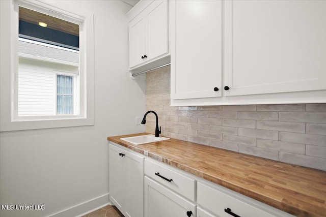 125 Water St, Madison, MS 39110 - kitchen with white cabinets, backsplash, and wooden counters