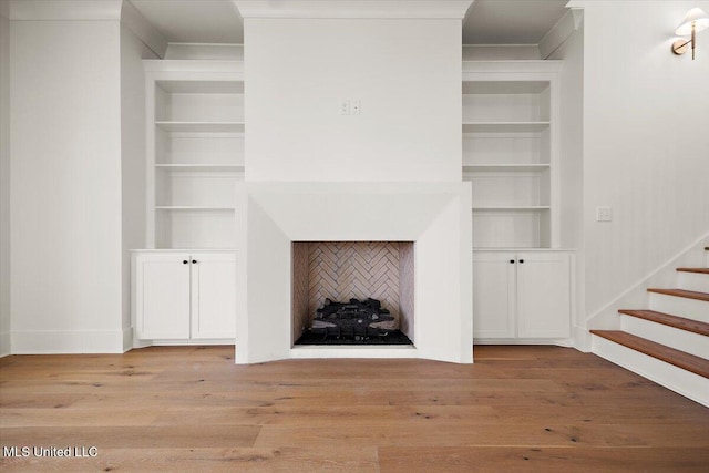 125 Water St, Madison, MS 39110 - unfurnished living room featuring built in features, wood finished floors, stairs, and crown molding