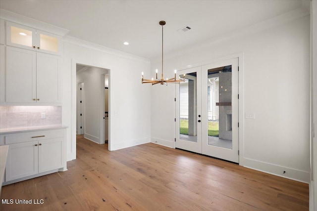 125 Water St, Madison, MS 39110 - unfurnished dining area with a chandelier, light wood-type flooring, french doors, recessed lighting, and ornamental molding