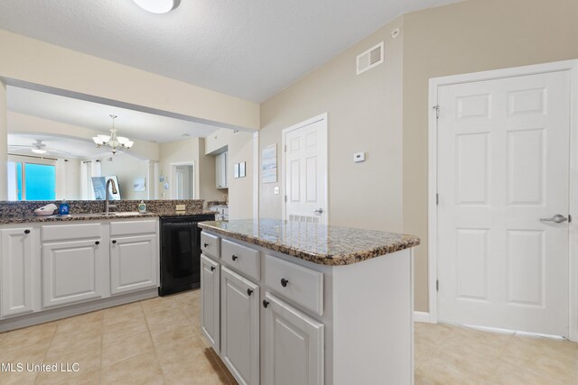 kitchen with dishwasher, sink, a textured ceiling, a kitchen island, and ceiling fan with notable chandelier