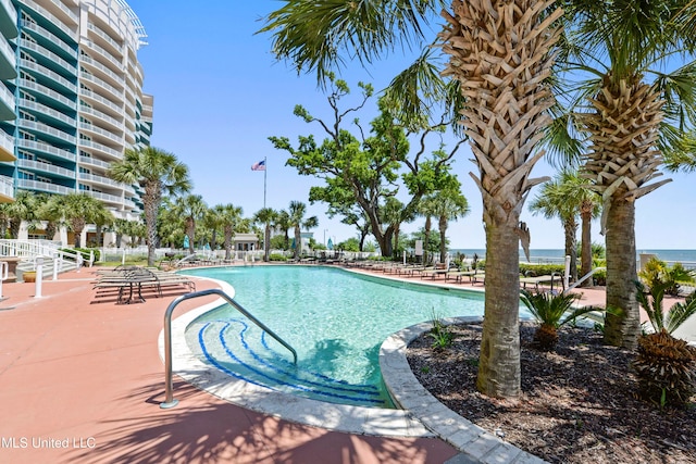 view of pool featuring a patio and a water view