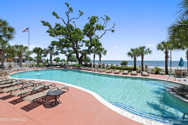 view of swimming pool with a patio area and a water view