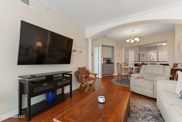 living room featuring dark hardwood / wood-style floors, an inviting chandelier, and crown molding