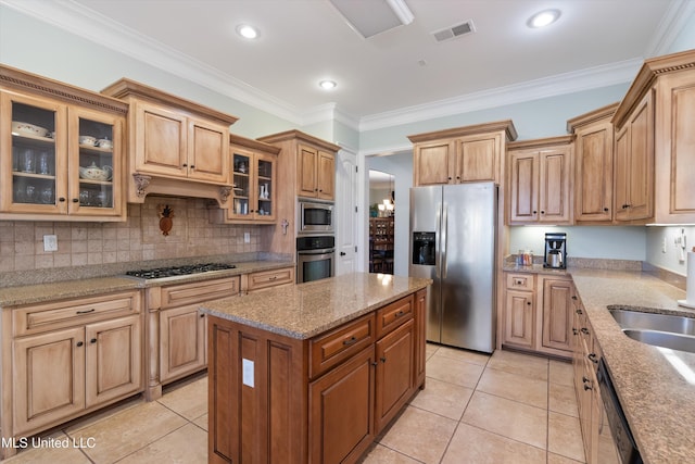 kitchen featuring stainless steel appliances, a center island, visible vents, and crown molding