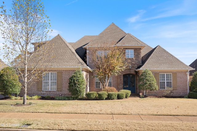 traditional-style house featuring brick siding and a shingled roof