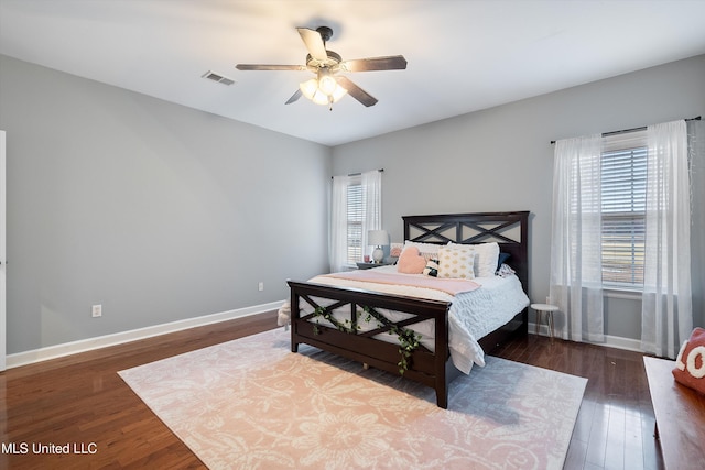 bedroom featuring visible vents, ceiling fan, baseboards, and wood finished floors